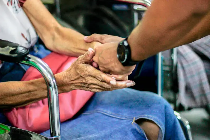 man holding hand with woman on chair